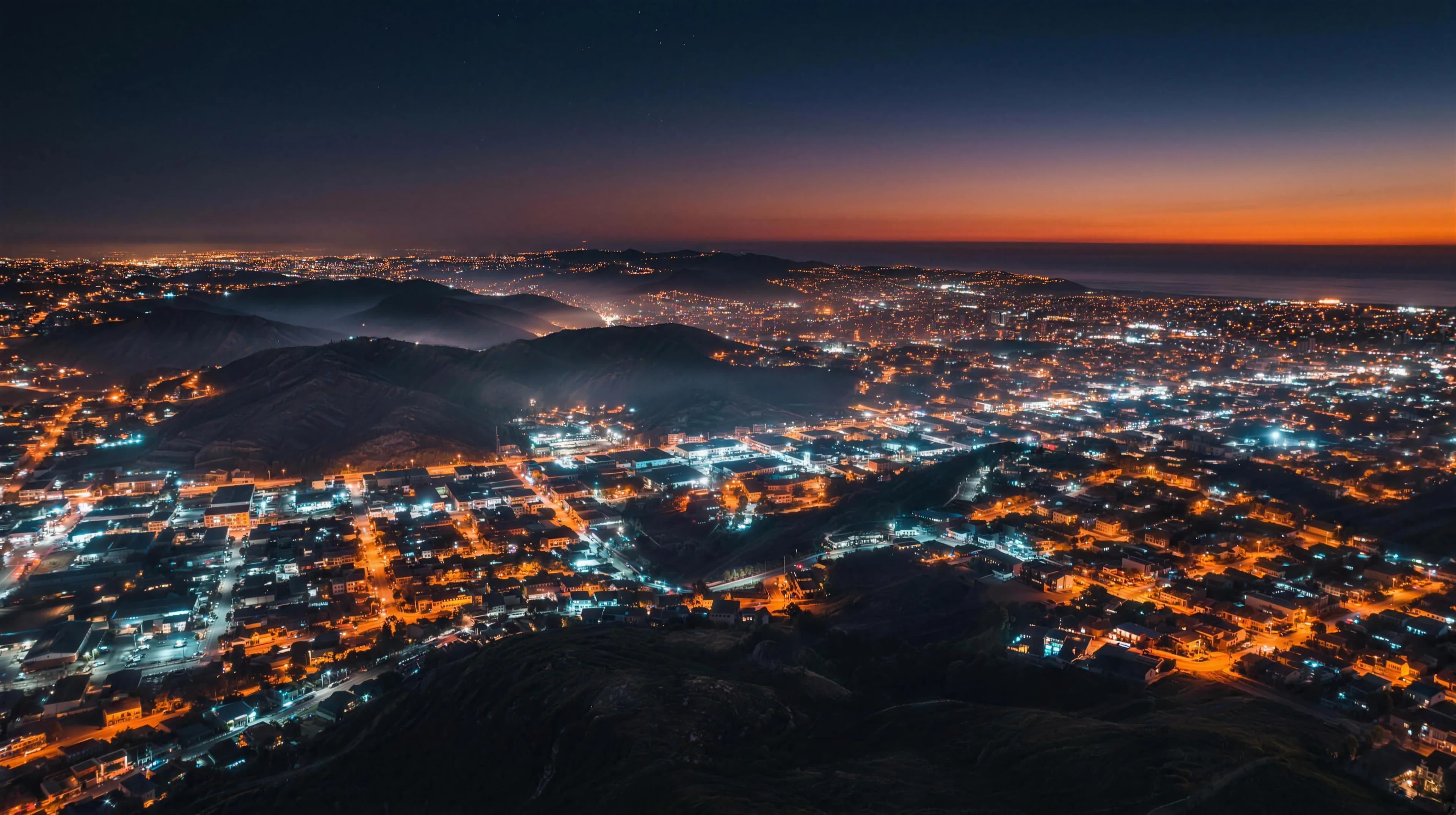 Vista aérea nocturna de Tijuana con las colinas iluminadas hasta el horizonte